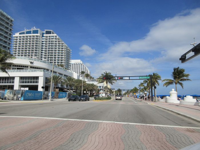 A1A beside the beach, with hotel towers, palm trees and a wide crosswalk.