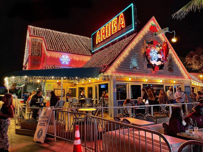 The lit Aruba Beach Cafe sign and thatched roof at night, at the end of Commercial Boulevard.