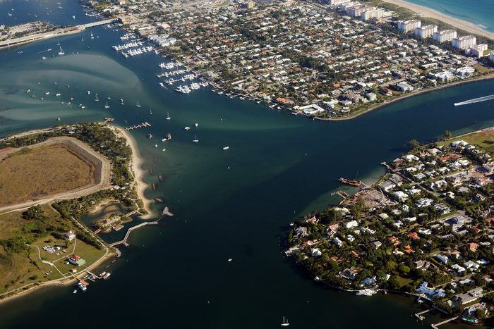 Aerial view across the Intracoastal Waterway to a green park, the barrier island and the ocean.